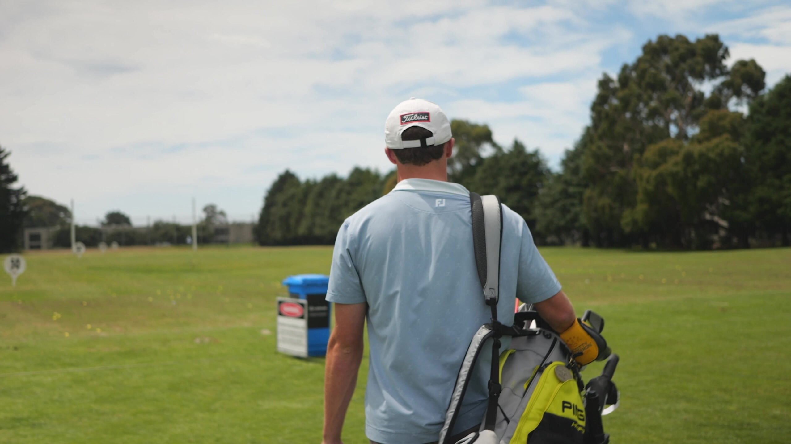 Golfer carrying a golf bag onto the course at Russley